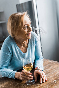 高龄妇女有选择地将注意力集中在看离家和在家里举着酒杯的图片