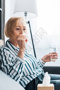 头鼻流湿子的生病高龄妇女寒冷背景图片