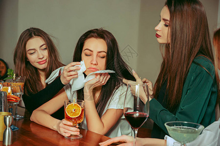 压力女朋友在酒吧喝酒他们正坐在一张木桌旁图片