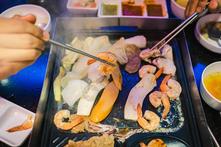 享受在韩国餐厅与家人一起吃韩式BBQ传统著名食背景图片