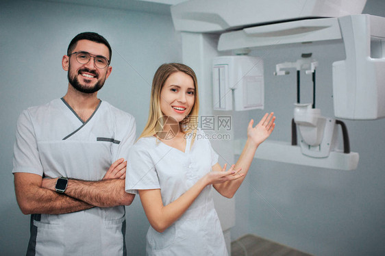 积极的牙医站在X光室图片