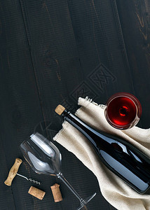 瓶子和葡萄酒杯软木箱和木质装饰品在暗木本底顶端视图片