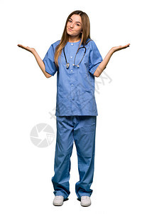 年轻护士在孤立的背景下举起肩膀时做出无关紧要的姿态图片