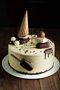 白巧克力蛋糕用棍子华夫饼锥和巧克力球上的冰棒装饰孩子们的生日蛋图片