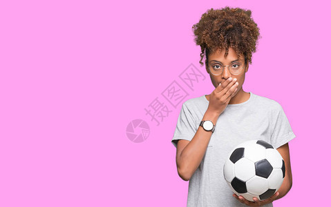 美籍年轻女子在孤立的背景面上用手顶着单身的嘴唇打足球图片