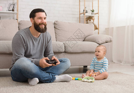 陪产假娱乐千禧一代男人用操纵杆和他可爱的小儿子玩电脑游戏图片