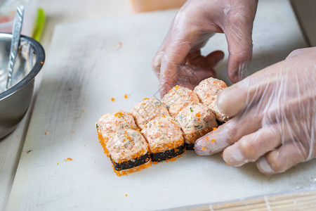 做日本寿司卷的烹饪手日本厨师在制作美味的寿司卷时图片