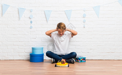 男孩庆祝他的生日用蛋糕把两只耳图片