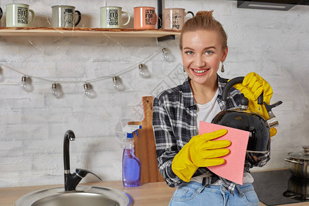 家庭服务和家务管理概念快乐的金发女士打扫厨房水壶手贴上橡皮图片
