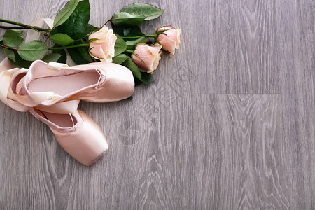 木地板上有玫瑰的芭蕾舞鞋图片