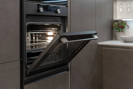 黑厨房橱柜内新的和现代内置烤炉图片