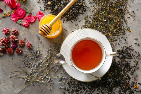 一杯热茶加蜂蜜在灰色背景图片