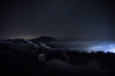 美丽的夜景与星夜山和森林有绿色草甸和山的夜森林在明亮的星夜或银河视图图片