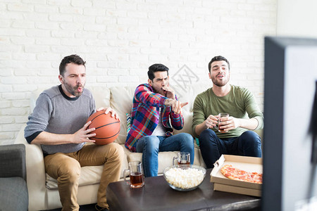 当篮球运动员错过了灌篮时朋友在看电视图片