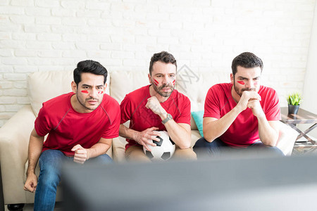 拉丁裔朋友在电视上小心观看足球运动员的一举动图片