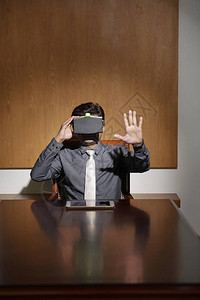 在虚拟现实中的商人坐在会议室桌边的图片