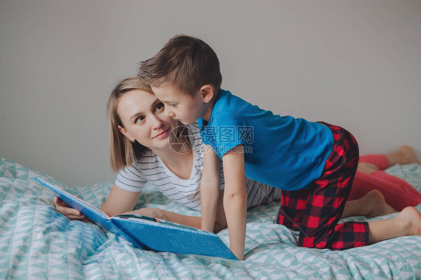 两个人的家庭坐在卧室看书的床上母亲和儿子在家共度时光父母谈话与孩子交流真实图片