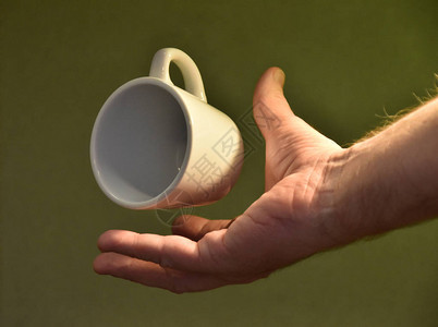 男人的手拿着茶杯绿色背景图片