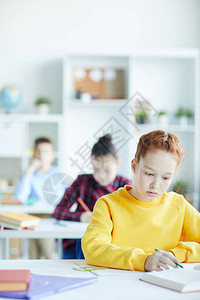 聪明女孩在课堂上个人工作时学习文学课读图片