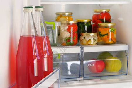 冰箱里装着自制红果汁和各种咸菜有机蔬菜罐头的瓶子图片