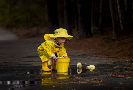 一个小孩在雨中玩耍而小妞图片