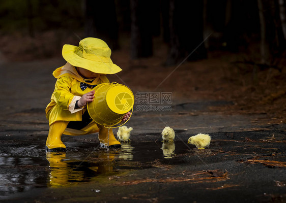 一个小孩在雨中玩耍而小妞图片