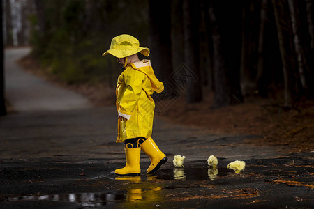 一个小孩在雨中玩耍而小妞图片