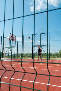 年轻人在野外法庭上独自打篮球时图片