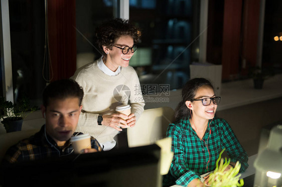 三名青年群体在深夜暗办公室工作图片