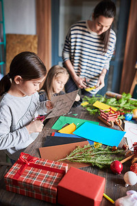 两个小女孩在艺术和工艺课上为圣诞剪纸制作手工装饰品的肖图片