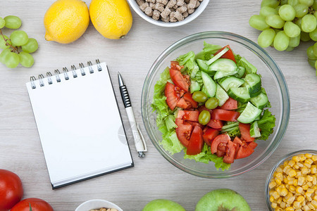 配有新鲜蔬菜和水果的饮食计划笔记本及餐桌顶视图片