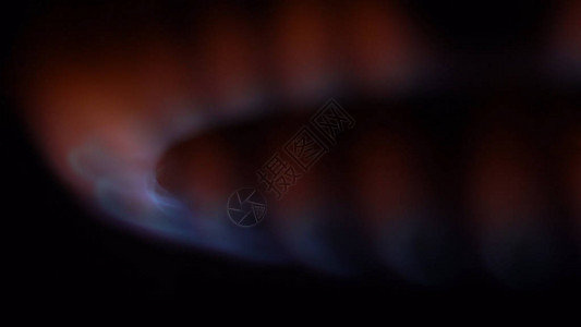 黑暗中燃烧的炉火的特写镜头黑暗中厨房用微弱火力工作的燃气烧图片