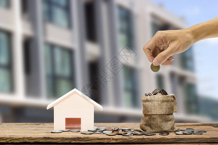 攒钱买房地产投资理念一个男人手拿着硬币图片