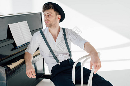 坐在白椅子上靠着钢琴的英图片