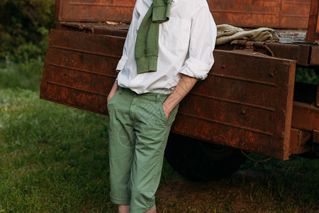 一个男孩穿着白衬衫和绿裤子图片