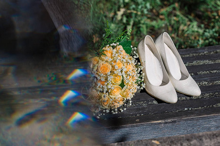阳光下新娘的结婚捧花戒指和鞋子图片