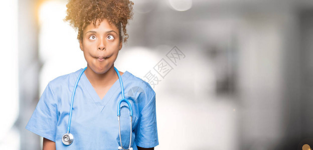 身处孤立背景的非裔美国女医生用嘴唇疯狂和滑稽的手势做鱼脸图片