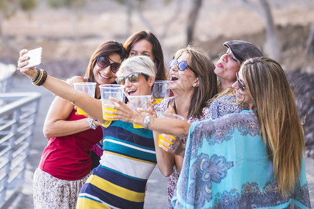 一群快乐开朗的白人年轻女用塑料眼镜敬酒和碰杯图片