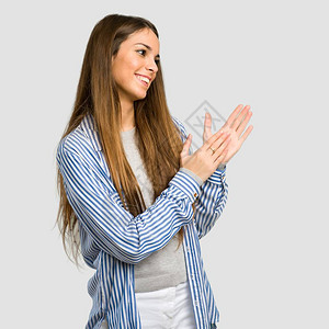 穿着条纹衬衫的年轻女孩在一次针对孤立灰色背景的会议中发言图片