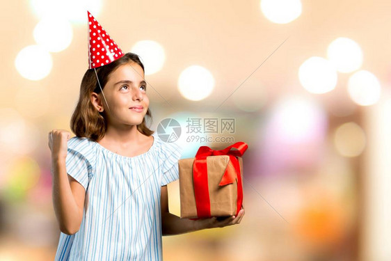 在生日派对上的小姑娘拿着礼物庆祝无重点背景胜利的生图片