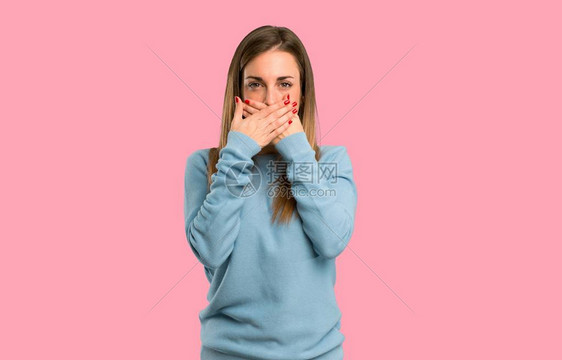 穿着蓝衬衫的金发女人用手亲张嘴说一些与世隔绝的粉红背图片