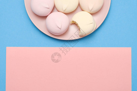蓝色和粉红色背景板上的美味和甜美的圆形棉花糖图片