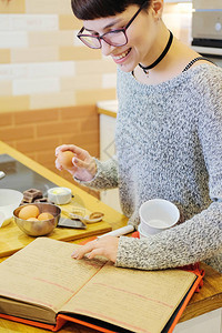 短发女人用烹饪书籍做巧克力食谱图片