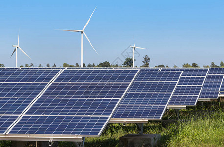 在混合发电厂系统中发电的多晶硅太阳能电池板和风力涡轮机的行阵列从自然中提取可替背景图片