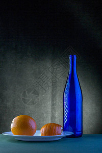 蓝瓶和橙子的静物图片