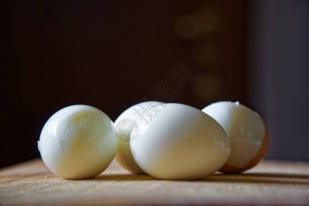 木板旁有贝壳的硬煮鸡蛋背景图片