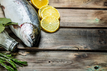 生海鱼鲑配柠檬角香草和香料木制背景图片