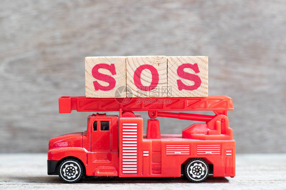 红色消防车在木本背景上用SOS字封住信条以拯救我们的灵魂船或肩膀图片
