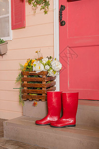 房子台阶上的红色胶鞋女式防水靴亮红色的园艺靴雨天时尚花园雨鞋雨天的靴子秋图片