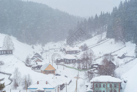 降雪期间乌拉尔村的冬季景观图片